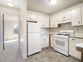 A kitchen with white refrigerator and stove at Dupont Lakes Apartments in Fort Wayne, IN