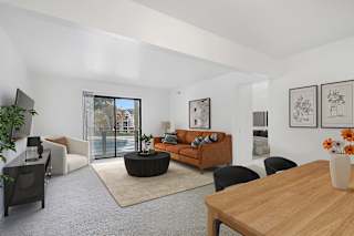 A living room with a brown sofa and a wooden table at Dupont Lakes Apartments in Fort Wayne, IN