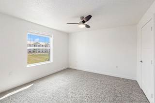 A bedroom with a ceiling fan and a window showing a view at Eagle Ridge Apartment Homes, Traverse City, MI 49685