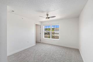 Bedroom with plush carpeting and large window at Eagle Ridge Apartment Homes, Traverse City, 49685