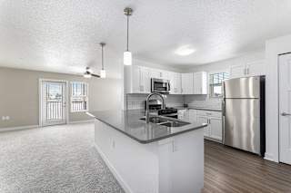 A kitchen with a stainless steel refrigerator and a sink at Eagle Ridge Apartment Homes, Traverse City