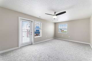 An enlarged living room with a ceiling fan and two windows at Eagle Ridge Apartment Homes, Traverse City