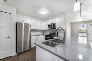 A kitchen with a stainless steel refrigerator and a sink at Eagle Ridge Apartment Homes, Traverse City, Michigan