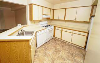 Kitchen with white cabinets and gas range at Emerald Park Apartments, Kalamazoo, 49001