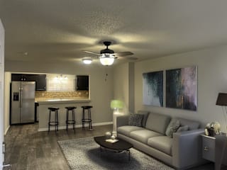 A living room with a grey couch and a ceiling fan.