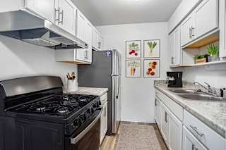 A kitchen with a stainless steel stove top and a refrigerator at Fairlane Apartments in Springfield, 49037