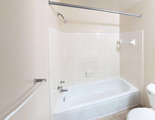 A full bathroom with a bath tub, toilet, and shower at Glen Oaks Apartments, Michigan, 49442