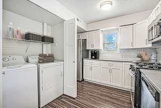 A white kitchen with hard surface floors and a washer and dryer at Green Ridge Apartments, Grand Rapids, 49544