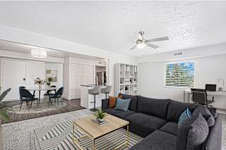An enlarged living room with a grey couch and a coffee table at Green Ridge Apartments, Grand Rapids, 49544