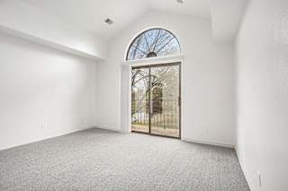 an empty living room with a cathedral ceiling at Hampton Lakes Apartments, Michigan, 49534