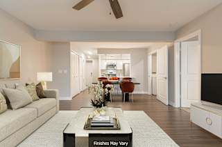 a living room with a couch and a coffee table in front of a tv at Hillside Apartments, Wixom, 48393