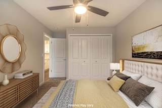 a bedroom with a large bed and a ceiling fan at Hillside Apartments, Wixom