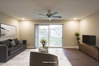 a living room with a couch and a tv at Hillside Apartments, Wixom