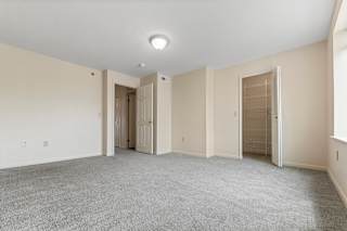 A large empty bedroom with a walk-in closet at Hunters Pond Apartment Homes, Champaign, IL, 61820