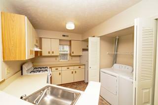 a kitchen with a sink and a washer and dryer  at Hurwich Farms Apartments, South Bend, IN