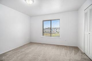 Bedroom with a window and carpet  at Hurwich Farms Apartments, South Bend, IN, 46628