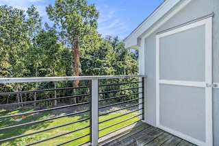 a balcony with enclosed storage and a view of the woods at Hurwich Farms Apartments, Indiana