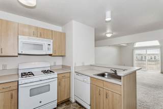 A two bedroom kitchen overlooking a living room with cathedral ceiling at Limestone Creek Apartment Homes, Madison, AL at Limestone Creek Apartment Homes, Madison, 35756