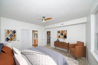 a bedroom with a ceiling fan and a doorway to an attached bath at Limestone Creek Apartment Homes, Madison, AL