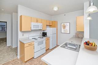 a kitchen with white appliances and wooden cabinets at Limestone Creek Apartment Homes, Madison, AL