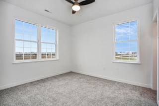 an empty room with two windows and a ceiling fan at Meadowbrooke Apartment Homes, Michigan
