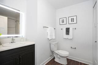a bathroom with a toilet and a sink and a mirror at Meadowbrooke Apartment Homes, Grand Rapids, Michigan