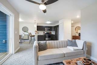 a living room with a couch in front of a kitchen at Meadowbrooke Apartment Homes, Grand Rapids, Michigan