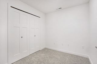 a bedroom with two closets and a carpeted floor at Meadowbrooke Apartment Homes, Michigan