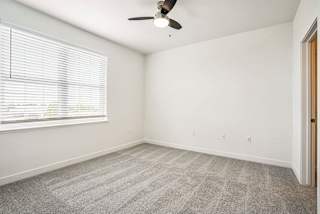 an empty living room with a window and a ceiling fan at Meadowbrooke Apartment Homes, Grand Rapids