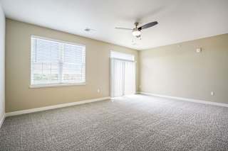 an empty living room with a ceiling fan and a window at Meadowbrooke Apartment Homes, Grand Rapids, Michigan