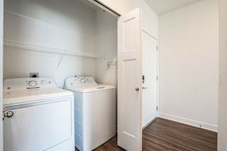 a white laundry room with two washes and a dryer at Meadowbrooke Apartment Homes, Michigan
