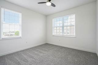 an empty room with two windows and a ceiling fan at Meadowbrooke Apartment Homes, Grand Rapids, 49512