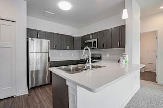 a kitchen with a sink and a refrigerator at Meadowbrooke Apartment Homes, Grand Rapids, MI