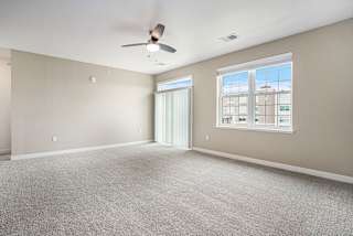 an empty living room with a ceiling fan and a window at Meadowbrooke Apartment Homes, Michigan, 49512