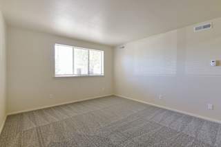 an empty living room with a window and carpet at Old Monterey Apartments, Missouri