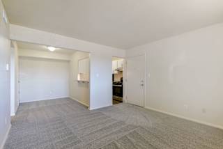 an empty living room with a door to the kitchen at Old Monterey Apartments, Springfield
