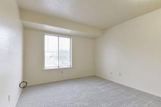 an empty living room with a window and carpet at Old Monterey Apartments, Springfield
