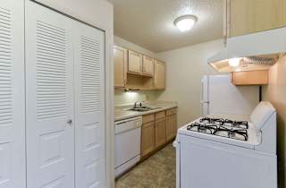 a kitchen with a stove and a refrigerator at Old Monterey Apartments, Missouri, 65807