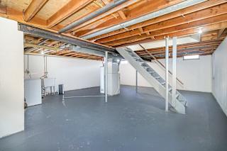 A basement with a washer and dryer and lots of storage space at Mount Royal Townhomes in Kalamazoo, MI