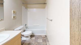A bathroom with a toilet, sink, and bathtub at Mount Royal Townhomes, Kalamazoo, MI