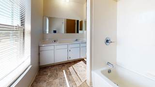 a bathroom with a tub and a sink and a mirror at Mount Royal Townhomes, Michigan
