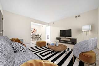 a living room with a gray couch and a coffee table in front of a flat screen tv at Timberbrook Apartments, Peoria, 61614