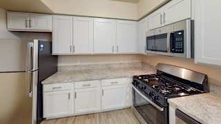 a kitchen with white cabinets and a stove and a microwave at North Pointe Apartments in Elkhart, IN