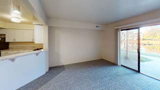 a living room, kitchen and a sliding glass door to a patio at North Pointe Apartments in Elkhart, IN