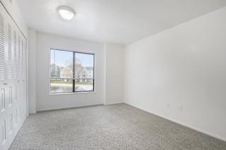 a bedroom with carpet and large window at North Pointe Apartments in Elkhart, IN