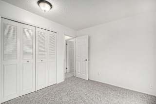 an empty bedroom with white closet doors at Normandy Village Apartments, Michigan City, IN