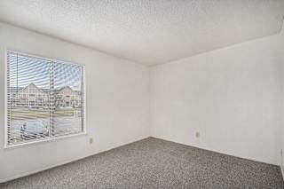bedroom with a large window and carpeting at Normandy Village Apartments, Indiana, 46360