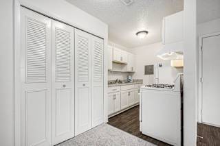 a white kitchen with white cabinets and white appliances at Normandy Village Apartments, Michigan City, IN, 46360
