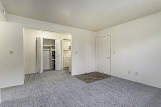 a living and dining room with a closet and carpet at Normandy Village Apartments, Michigan City, IN, 46360