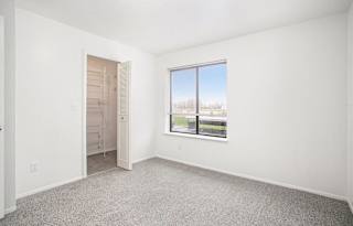 A bedroom with a large window and a walk-in closet at North Pointe Apartments, Elkhart, IN, 46514